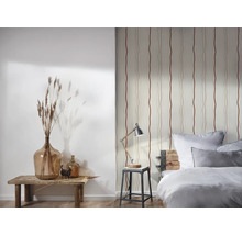 Dekoratives Schlafzimmer mit gemusterter Tapete, Tischlampe und Glasvasen