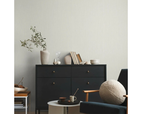 Wohnzimmer mit Kommode, Sessel, Tisch und Dekorationsgegenständen
