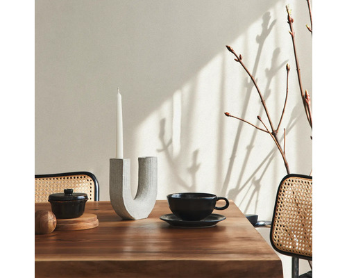 Tischdekoration mit Kerzenhalter, Kerze, Schale und Tasse auf Holztisch
