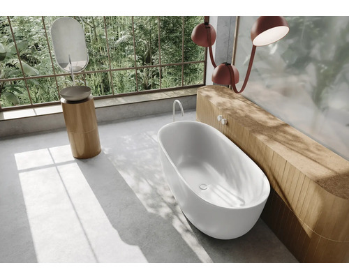 Badezimmer mit freistehender Badewanne, Waschtisch und großem Fenster mit Blick ins Grüne
