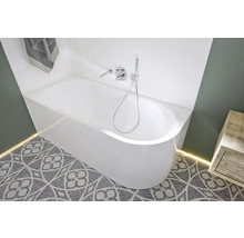 Badezimmer mit weißer Badewanne, Armatur und gemusterten Bodenfliesen