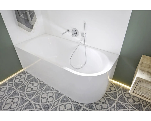 Badezimmer mit weißer Badewanne, Armatur und gemusterten Bodenfliesen