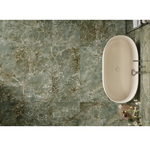 Badezimmer mit Badewanne und grünen Bodenfliesen in Marmoroptik.