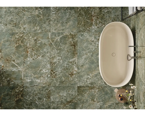 Badezimmer mit Badewanne und grünen Bodenfliesen in Marmoroptik.