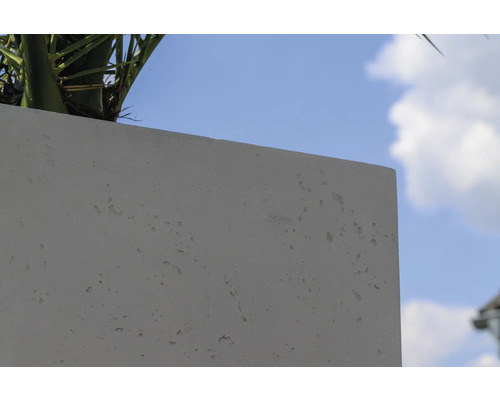 Detailansicht eines Pflanzkübels aus Beton vor blauem Himmel