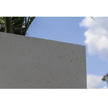 Detailansicht eines Pflanzkübels aus Beton vor blauem Himmel