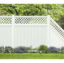 Weißer Gartenzaun mit Lattenmuster und Blumenbeet