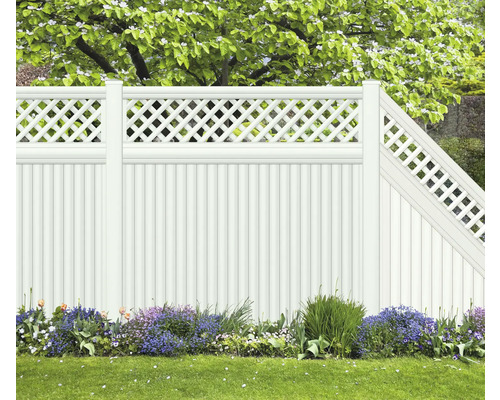 Weißer Gartenzaun mit Lattenmuster und Blumenbeet