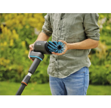 Eine Person hält eine Gardena Bürste zur Reinigung von Oberflächen im Außenbereich