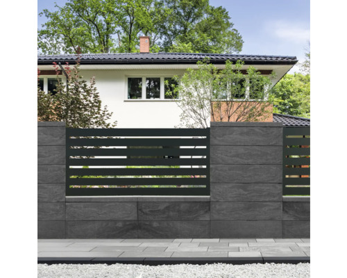 Moderne Grundstückseinzäunung mit Zaunelementen und Mauersteinen vor einem Wohnhaus