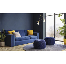 Wohnzimmer mit blauem Sofa, Zierkissen, runden Hockern und Zimmerpflanzen