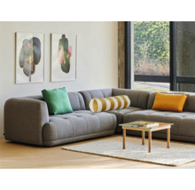 Wohnzimmer mit grauer Eckcouch, Kissen, Tisch und Bildern an der Wand.