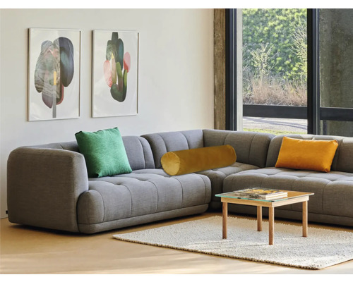 Graues Ecksofa mit Kissen und Couchtisch im Wohnzimmer.