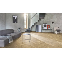 Modernes Wohnzimmer mit Fischgrätparkett Bodenbelag aus Eichenholz, grauen Sichtbetonwänden und einer minimalistischen Treppenkonstruktion.