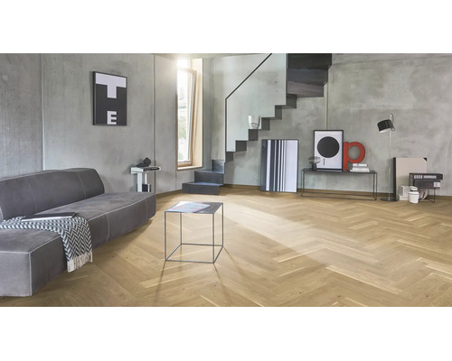 Modernes Wohnzimmer mit Fischgrätparkett Bodenbelag aus Eichenholz, grauen Sichtbetonwänden und einer minimalistischen Treppenkonstruktion.