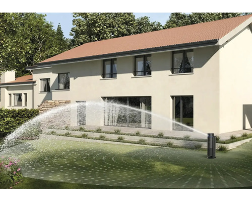 Versenkregner bewässert Rasen vor Wohnhaus