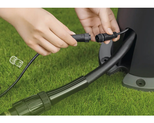 Anschluss eines Gartenstrahlerkabels mit Stecker auf Rasenfläche
