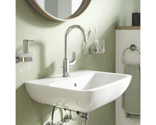 Waschbecken mit Armatur, Seifenspender, Zahnputzbecher und Handtuchring im Badezimmer