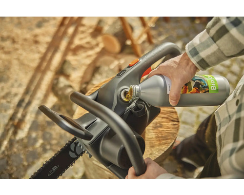 Person befüllt Kettensäge mit Öl