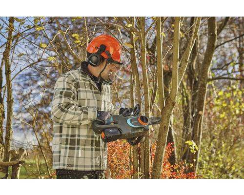 Mann mit Schutzhelm und Akku-Kettensäge beim Baumschnitt