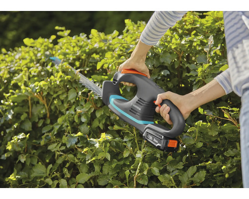 Akkubetriebene Heckenschere im Einsatz zum Beschneiden einer Hecke