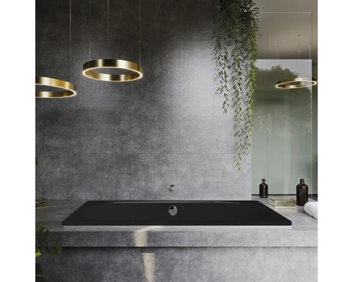 Badezimmer mit schwarzer Badewanne, runden Deckenleuchten und Betonwand