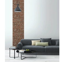 Wohnzimmer mit grauer Couch, Beistelltischen und Backsteinwand