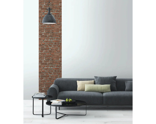 Wohnzimmer mit grauer Couch, Beistelltischen und Backsteinwand