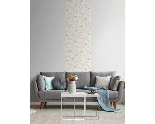 Wohnzimmer mit grauer Couch, weißem Tisch und Blumentapete