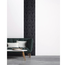 Wohnzimmer mit dunkler Mustertapete und Sofa