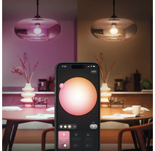 Smarte Lampe mit Steuerung per Smartphone-App über einem Esstisch