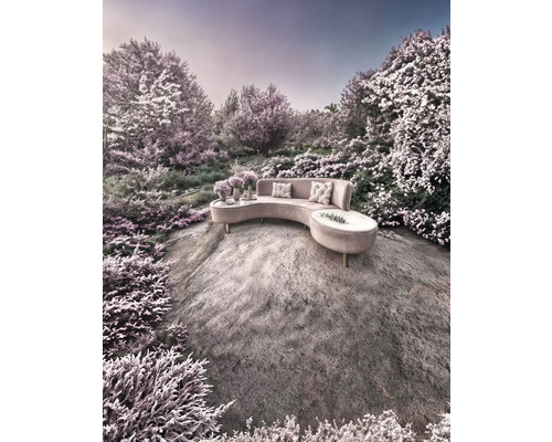 Halbrundes Sofa mit Kissen und Beistelltischen auf einem Felsen in einer Gartenlandschaft.