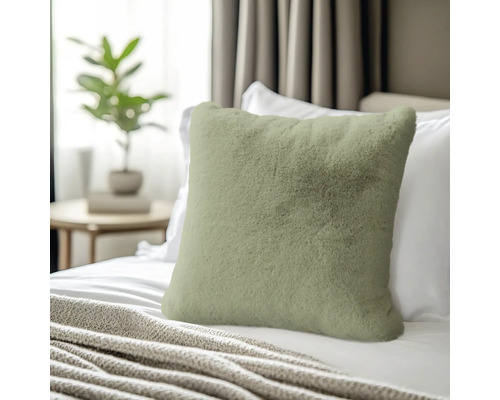 Dekokissen aus Fellimitat auf einem Bett