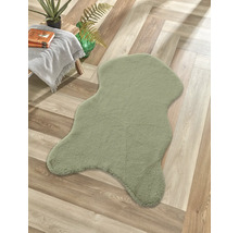 Grüner Teppich mit unregelmäßiger Form auf Holzboden
