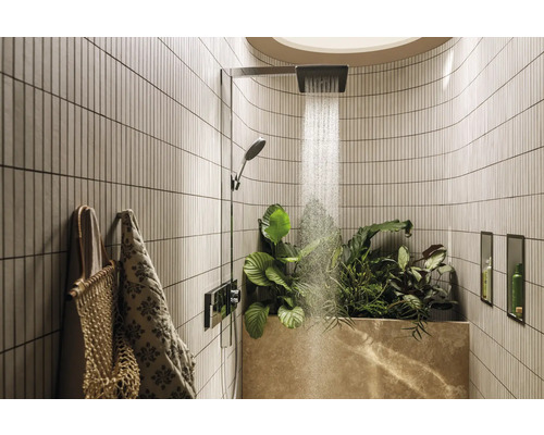 Badezimmer mit Dusche, Pflanzen und Handtüchern für eine natürliche Atmosphäre