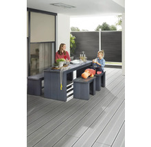 Familie sitzt an einem Gartentisch mit Bänken auf einer Terrasse mit Holzboden