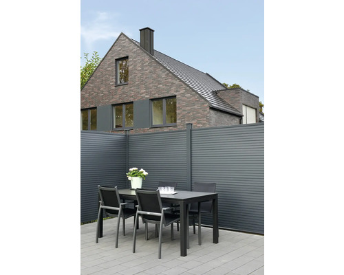 Außenbereich mit Gartenzaun, Esstisch und Stühlen vor einem Haus