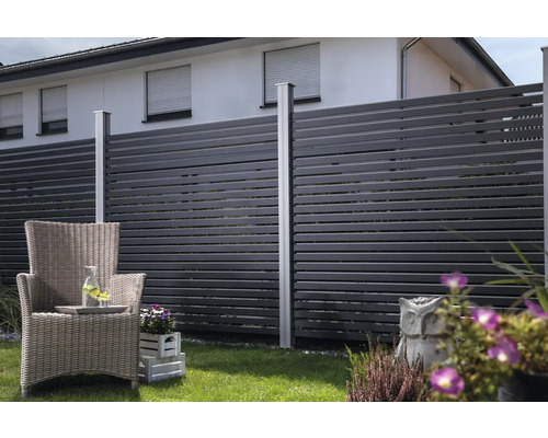 Garten mit Sichtschutzzaun, Korbstuhl und Bepflanzung