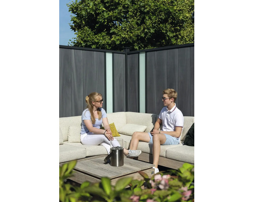 Szene mit einer Loungegruppe, einem Tischgrill und einem Sichtschutzzaun im Garten.