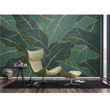 Wohnzimmer mit Blattmuster-Tapete in Grün und Gold, Sessel mit Hocker, Teppich und Beistelltisch mit Dekoration
