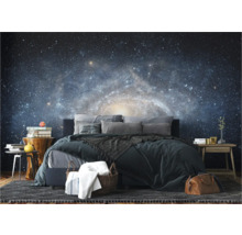 Schlafzimmer mit Galaxie-Fototapete, Bett, Teppich und Beistelltischen.