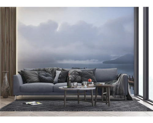 Wohnzimmer mit Sofa, Couchtischen und Fototapete mit Seemotiv.