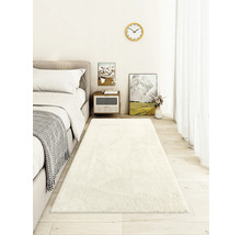 Schlafzimmer mit Bett, Nachttisch und langem, weichen Teppich