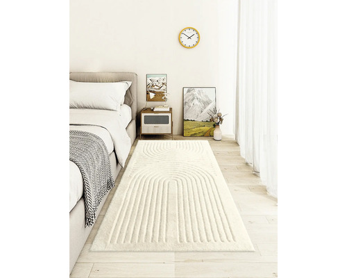 Schlafzimmer mit Bett, Nachttisch, Dekoration und einem hellen Teppich mit linearem Design.