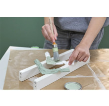 Anstreichen von Zierelementen mit Pinsel und Farbe.