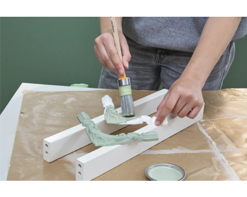 Anstreichen von Zierelementen mit Pinsel und Farbe.