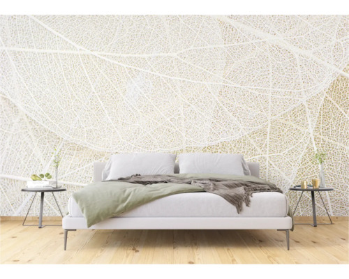 Schlafzimmer mit weißer Bettwäsche und Fototapete mit Blattmotiv