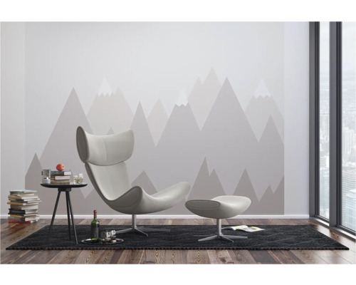 Modernes Wohnzimmer mit Sessel, Hocker, Beistelltisch und Bergmotiv-Tapete.