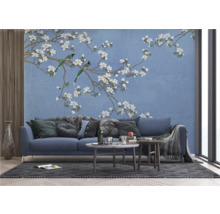 Wohnzimmer mit einer blauen Couch vor einer Wandtapete mit Vogel- und Blütenmotiv