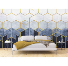 Ein Schlafzimmer mit einer Tapete mit goldenen geometrischen Formen hinter einem Bett